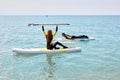 Female experienced surfer on SUP board at sea. Young woman on stand up paddleboard