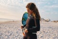 Female Extreme Sports Kite Surfer Prepping Kite On Beach At Sunset