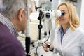 Female eye doctor looks at patient eyes using apparatus Royalty Free Stock Photo