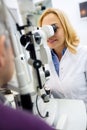 Female eyes doctor work with apparatus and checks eyes to patient Royalty Free Stock Photo