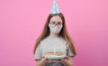 Female with facemask holding cake Royalty Free Stock Photo