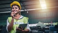 Female factory worker using handheld radio receiver for communication.