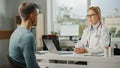 Female Family Doctor is Talking with Healthy Young Male Patient During Consultation in a Health Royalty Free Stock Photo