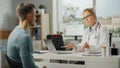 Female Family Doctor is Talking with Healthy Young Male Patient During Consultation in a Health Royalty Free Stock Photo