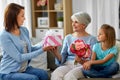 Female family giving present to grandmother Royalty Free Stock Photo