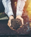 Female farmer holding soil arable ploughed dirt in cupped hands