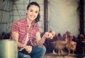 Female farmer picking fresh eggs in coop Royalty Free Stock Photo