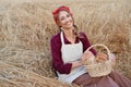 Female farmer sitting wheat agricultural field Woman baker holding wicker basket bread product Royalty Free Stock Photo