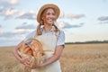 Female farmer standing wheat agricultural field Woman baker holding wicker basket bread product Royalty Free Stock Photo