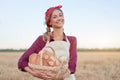 Female farmer standing wheat agricultural field Woman baker holding wicker basket bread product Royalty Free Stock Photo