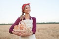 Female farmer standing wheat agricultural field Woman baker holding wicker basket bread product Royalty Free Stock Photo