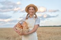 Female farmer standing wheat agricultural field Woman baker holding wicker basket bread product Royalty Free Stock Photo