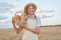 Female farmer standing wheat agricultural field Woman baker holding wicker basket bread product Royalty Free Stock Photo