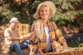 Female farmer in straw hat showing corn cob into the camera Royalty Free Stock Photo