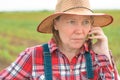 Female farmer talking on mobile phone in young green corn field Royalty Free Stock Photo