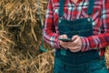 Female farmer typing sms message on mobile phone Royalty Free Stock Photo