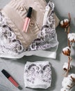 Female fashion background with lingerie, lipstick and flowers. Flat lay, top view. Beauty concept for blog, social media, magazine Royalty Free Stock Photo