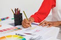 Female fashion designer drawing a sketch at desk in design studio