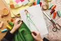 Female fashion designer working with fabric sample and drawn illustration