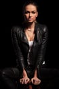 Female fashion model in leather jacket is sitiing on chair Royalty Free Stock Photo