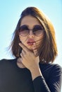 Female fashion model posing with sunglasses. Close-up portrait of a beautiful charming young attractive lady. Portrait Royalty Free Stock Photo