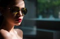 Female fashion model posing with sunglasses. Sexy. Close-up portrait of a beautiful charming young attractive woman in a Royalty Free Stock Photo