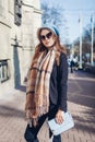 Female fashion. Stylish woman holding purse, wearing beret, sunglasses and scarf outdoors. Spring accessories Royalty Free Stock Photo