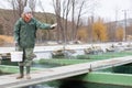 Female feeding fish on sturgeon farm Royalty Free Stock Photo