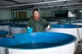 Female feeding fish on sturgeon farm Royalty Free Stock Photo