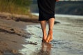 Female feet barefoot on a sandy beach in the water. Close-up of beautiful female legs. Wet foot Royalty Free Stock Photo