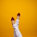 Female feet in beautiful red stiletto shoes, yellow background copy space. Royalty Free Stock Photo