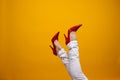 Female feet in beautiful red stiletto shoes, yellow background copy space. Royalty Free Stock Photo