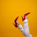 Female feet in beautiful red stiletto shoes, yellow background copy space. Royalty Free Stock Photo