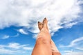 Female feet with blue nails with the summer sky in the background in Bornholm island, Denmark Royalty Free Stock Photo