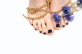 Female feet with blue pedicure and flower on white background