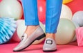 female feet in comfortable shoes loafers at colorful balloons, black friday