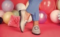 female feet in comfortable shoes loafers at colorful balloons, fashion