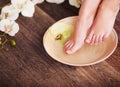 Female feet with drops of water, spa bowls, towels, flowers and candles.