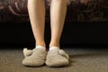 female feet in gray slippers on the carpet in the bedroom, feet in slippers, comfort Royalty Free Stock Photo