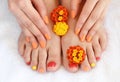 Female feet and hands with colorful manicure with red-orange flowers. Soft focus image Royalty Free Stock Photo