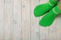 Female feet in knitted green socks on white wooden background. Royalty Free Stock Photo