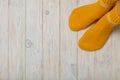 Female feet in knitted yellow socks on white wooden background. Royalty Free Stock Photo