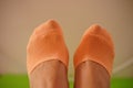 Female feet in orange socks on a green yoga mat Royalty Free Stock Photo