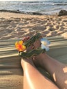 Female feet on the sand sith a Hawaiian, flower band