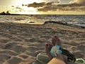 Female feet on the sand sith a Hawaiian, flower band