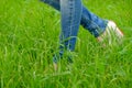 Female feet in shoes with wedge heels on green grass
