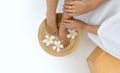 Female feet soaked in a bowl filled with water and flower petals, a depiction of relaxation and luxurious self-care Royalty Free Stock Photo