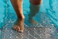 Feet on the steps of the pool Royalty Free Stock Photo