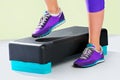 Female feet in violet sneakers on fitness step. Royalty Free Stock Photo