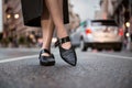 Female feet wear elegant leather shoes. Woman feet wearing high-heels on city street